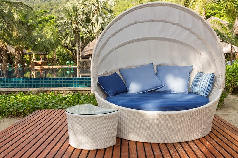 Outdoor lounge design with a round canopy chair in white