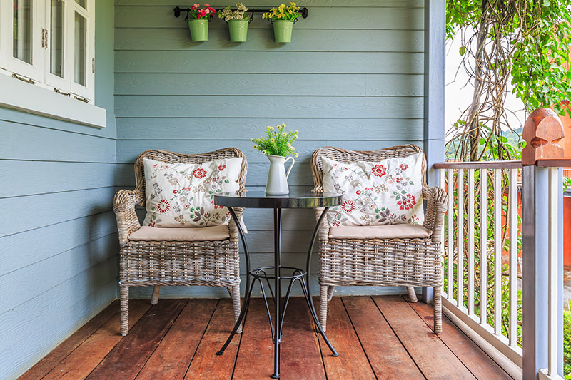 Simple outdoors design with a wicker chairs in a wooden veranda