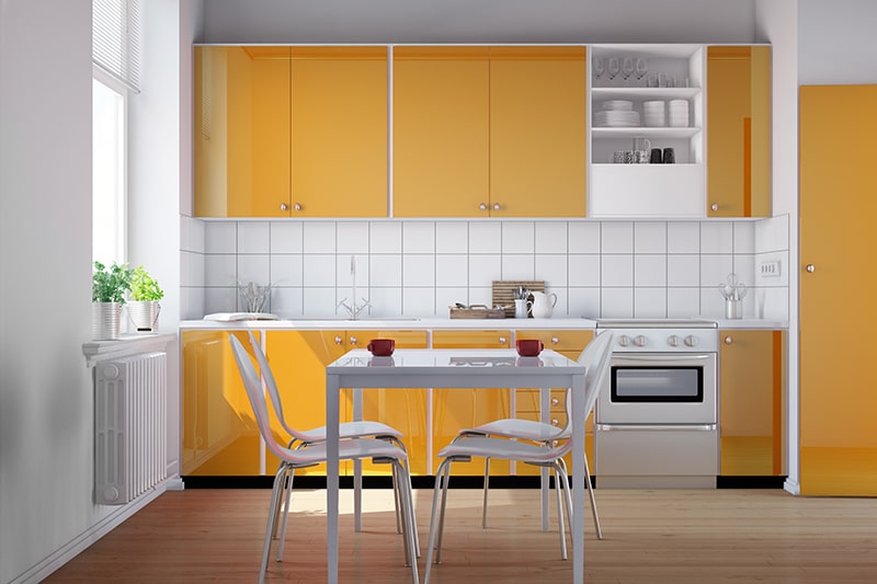 A kitchenette in white and yellow color which gives you a cheerful vibe.