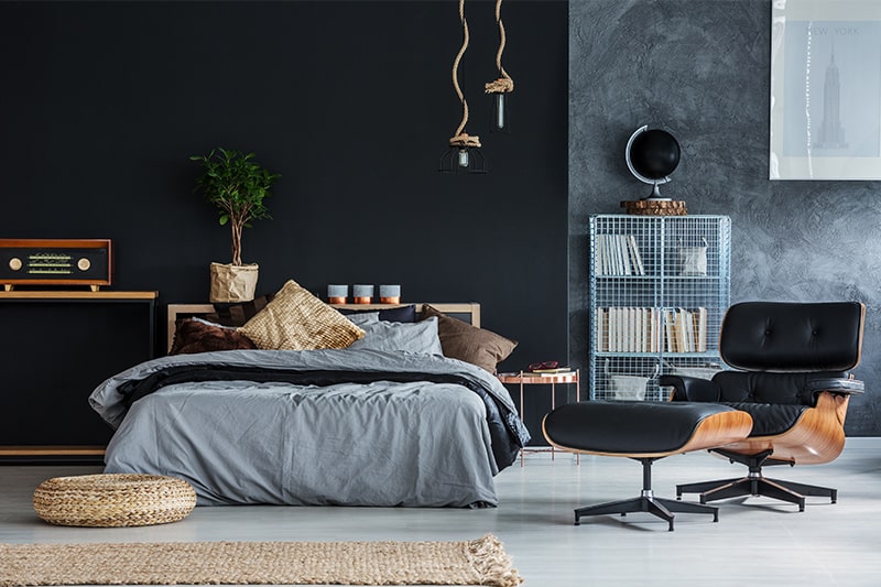 Black bedroom furniture with colourful accent chairs and knick-knacks elevate