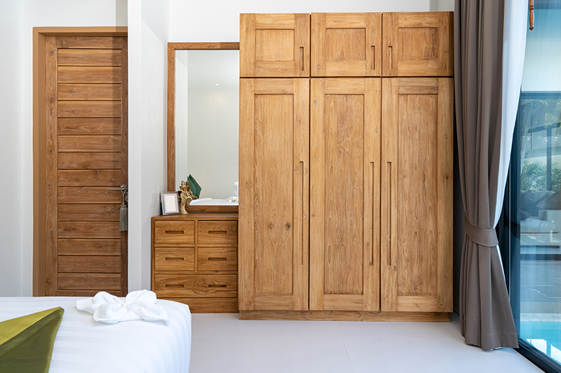 Traditional wooden door wardrobe gives a rustic look to the bedroom interiors