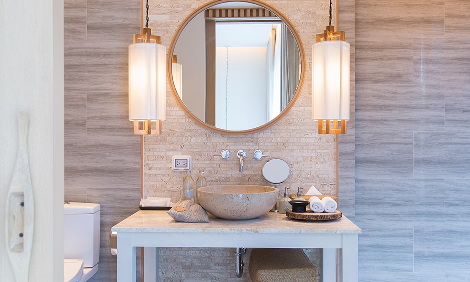 Glass pendant bathroom lights with a textured wall and a decorative mirror