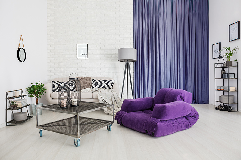 Purple colour room with a purple curtain and a purple sofa with modern and minimal furniture