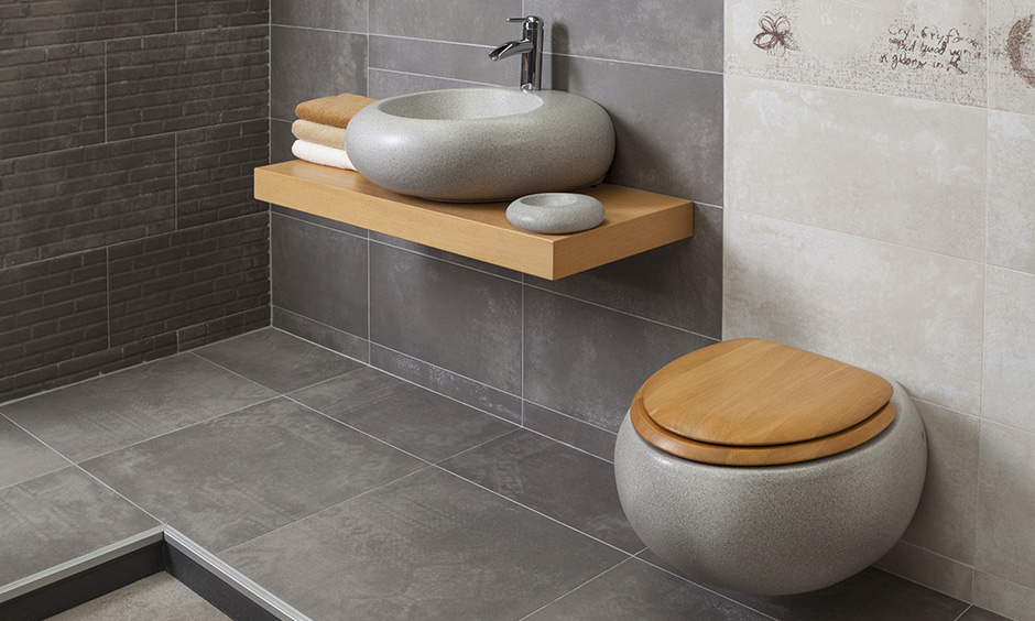 Bathroom sink designs made of granite against a wall of textured grey tiles