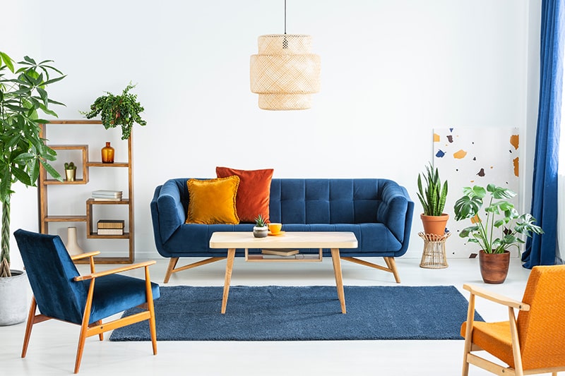 Sophisticated navy blue living room with a pair of wooden-framed armchairs, a coffee table, and sofa