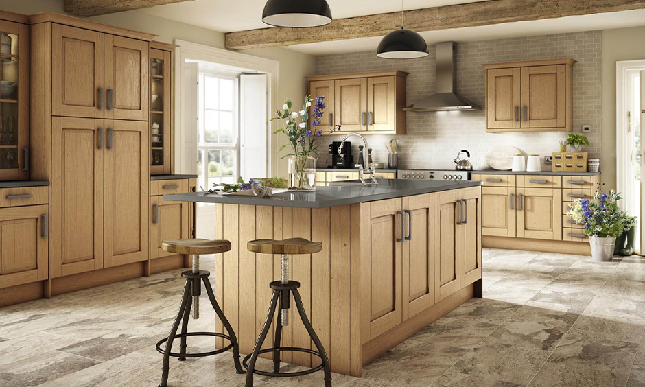 A traditional rustic farmhouse kitchen features exposed wooden beams on the ceiling