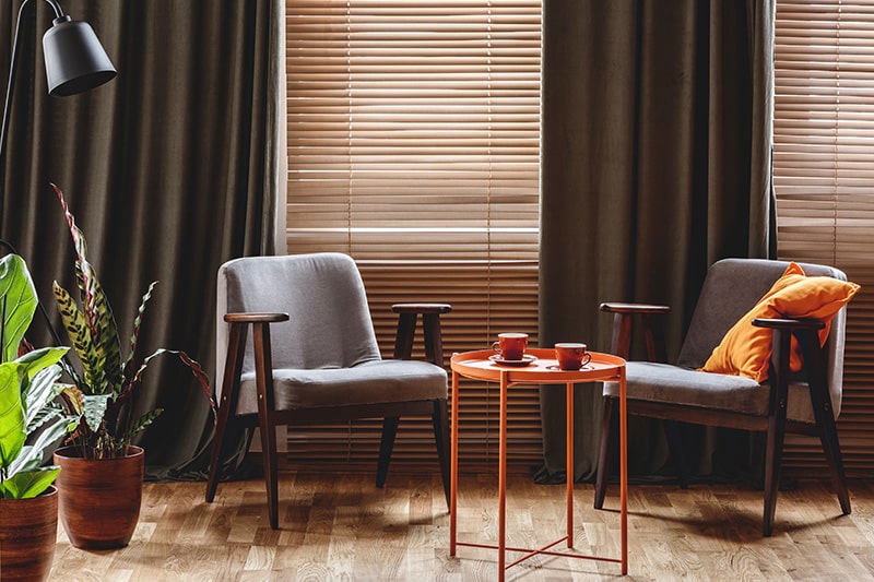 Ceiling to floor drapes and jute blinds combo gives peaceful reading corner