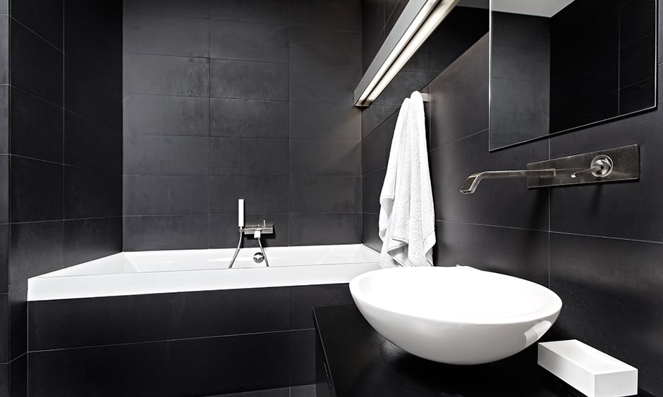 Classic black and white bathroom design black walls and floor and contrasted by the white bathtub