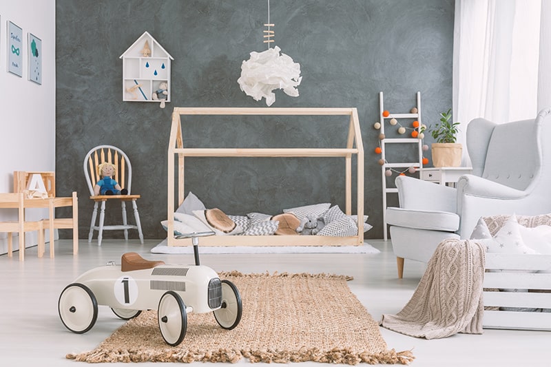 Decorate your kids room with scandinavian style by adding small-height wooden bed and a large arm chair