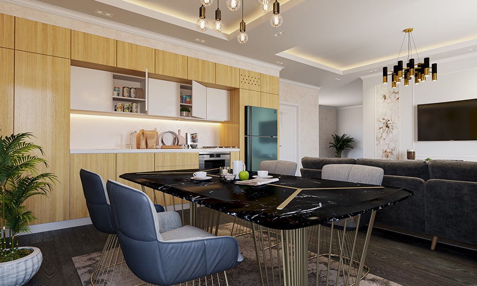 Dining colour combination with a black marble dining table with gold accents and light wood cabinetry