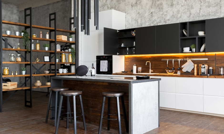 Industrial kitchen with a bold steel chair, cylindrical chandelier and pitch black top cabinets steals the show.