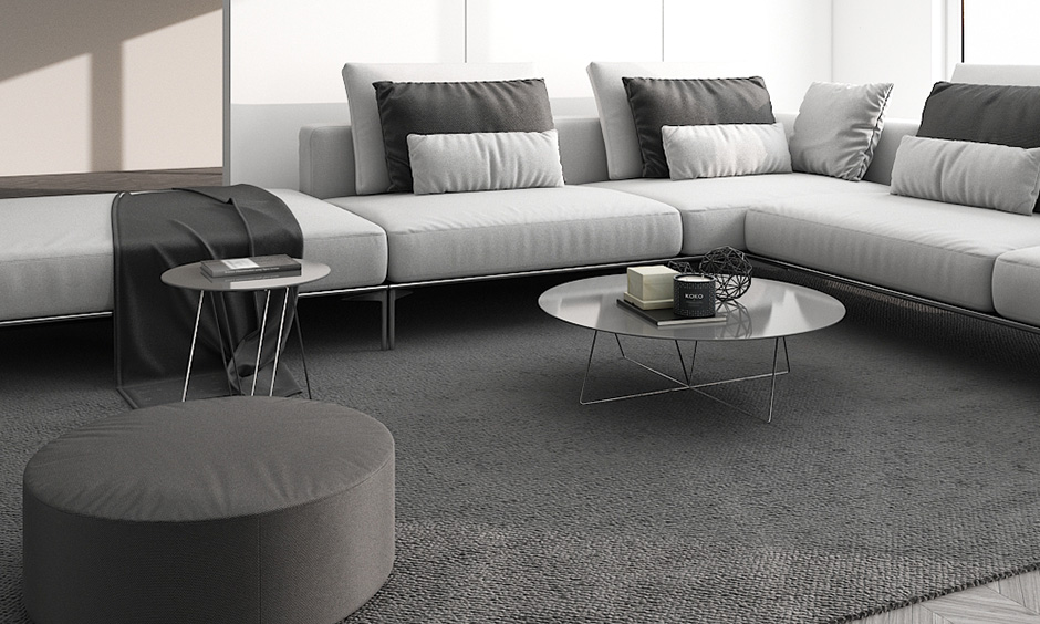 minimalist living room india with sofa set, monochrome pillows and a glass coffee table 