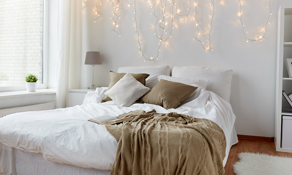 Add layers of fairy lights and hang them from the ceiling above the headboard is an excellent romantic bedroom lighting idea.