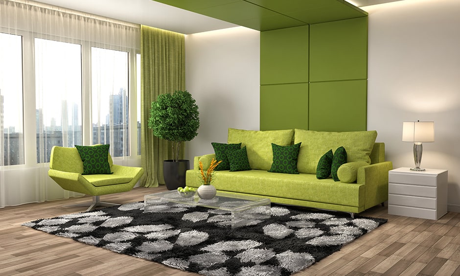 Green living room wall panel and green sofa gives this room a lively spirit