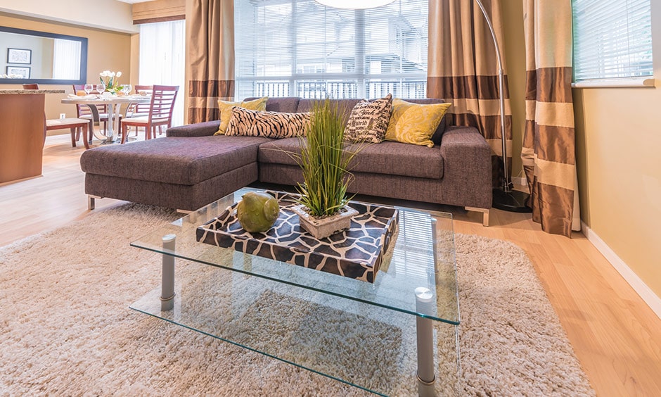 A glass coffee table for your living room with a lovely decor display on it