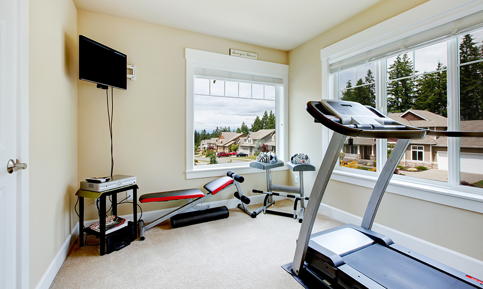 Home gym design for small space with a view of the neighbourhood and carpet flooring