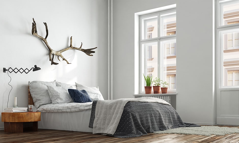 Modern minimalist bedroom interior design with a few potted plants on the window sill