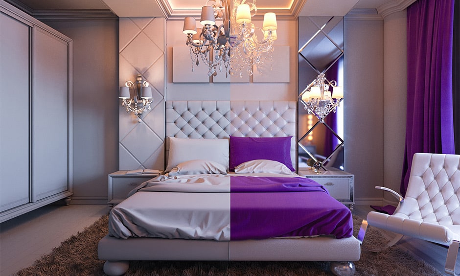 Modern purple bedroom decor with a chandeliers and comfortable white velvet armchair