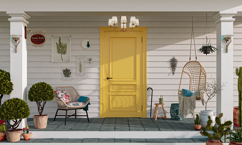 Yellow-painted front door, chandelier and wall-mounted lamps add a warm and inviting feel to this house front porch design.