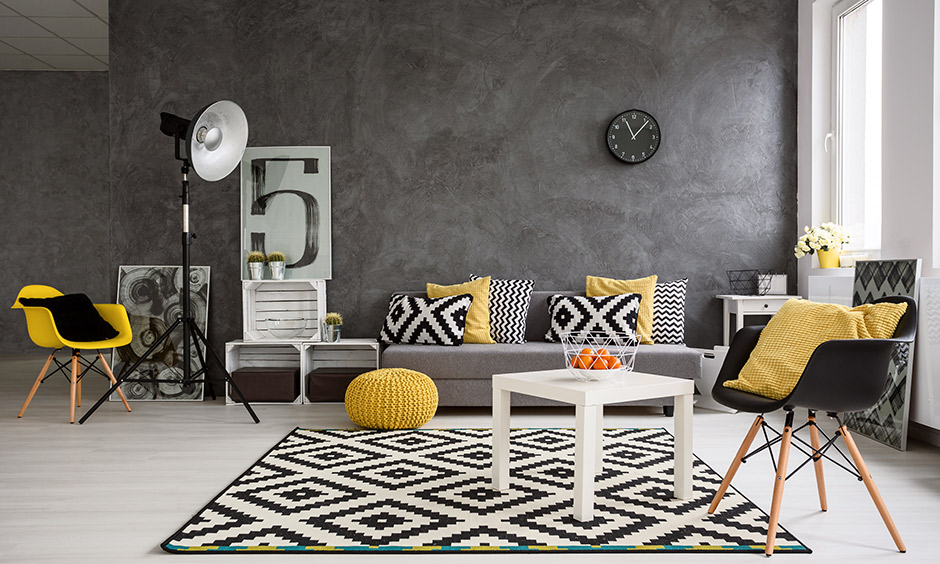 Black and yellow living room ideas, black wall and pops of a yellow pillow & chair bring out something different and unique