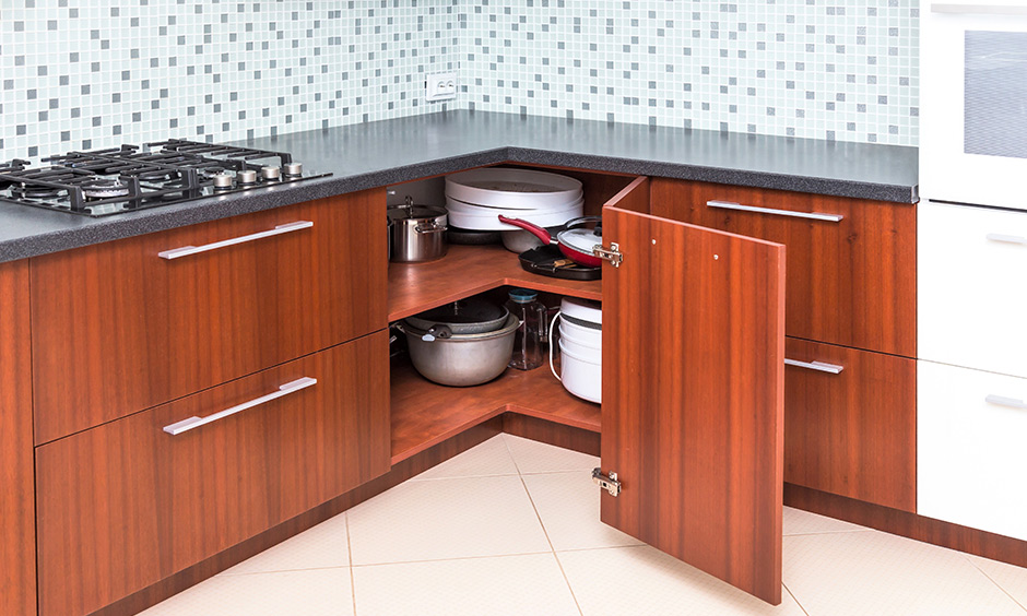 Modular kitchen corner cabinets with angular door and grey granite countertop exude warmth and cosiness.