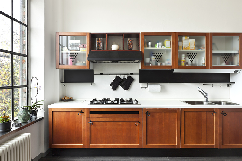 Modern wood kitchen cabinets with glass shutters bring subtle style to the overall look