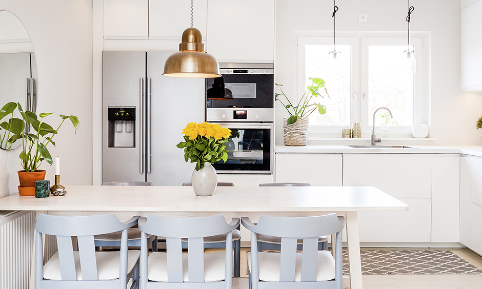 Modern minimalistic kitchen lighting design with bell-shaped pendant stands out even as a piece of art in this white kitchen