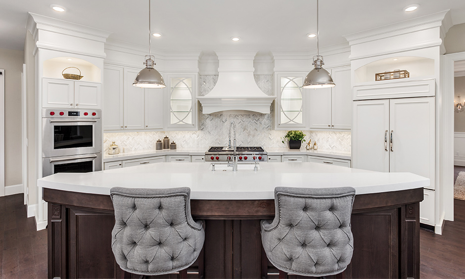 White luxury marble kitchen with a bar counter in an arch shape & domed shaped pendant lights looks elegant.