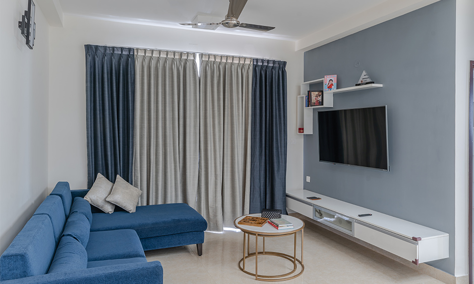 Design cafe interior designers in Kanakapura Bangalore designed this minimalistic living room with a wall-mounted floating TV unit.