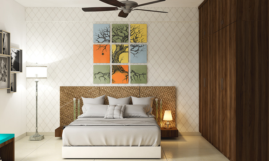 Master bedroom wall art paintings of an old tree in orange, blue, yellow and green colours are depicting nature's beauty.