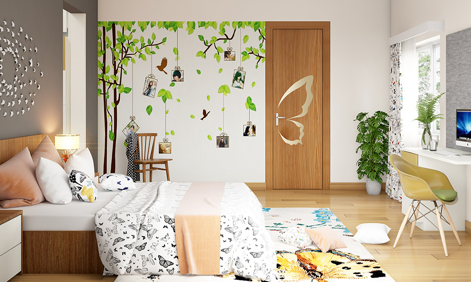 Wall art designs for bedroom with a wall sticker of a tree, birds, and birdcages with photographs brings nature touch.