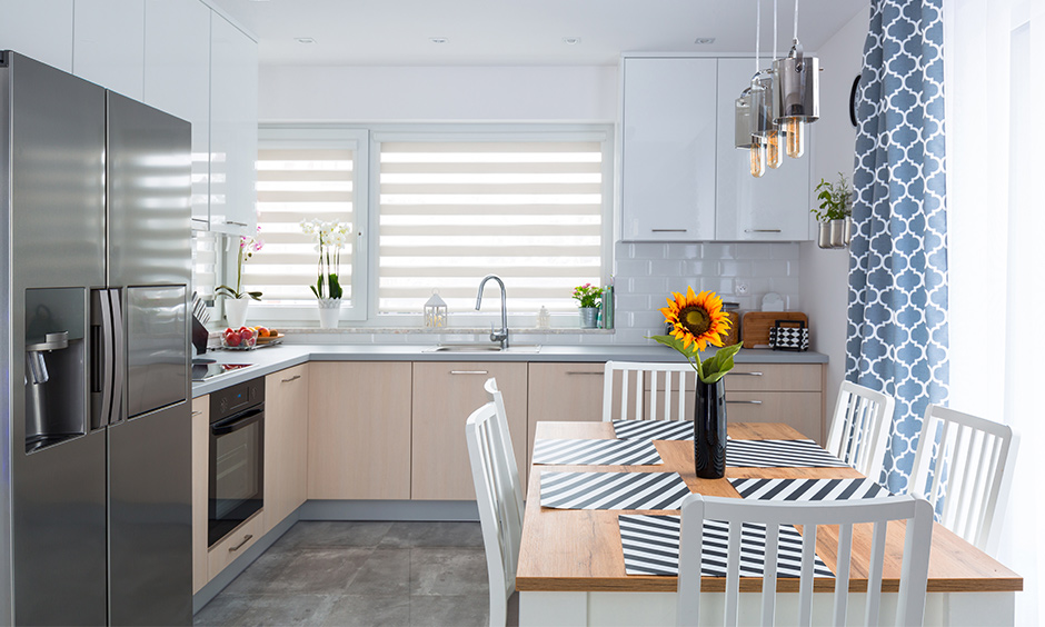 Decorating small kitchen spaces with a dining table & blue pattern curtains enhances the small kitchen decor