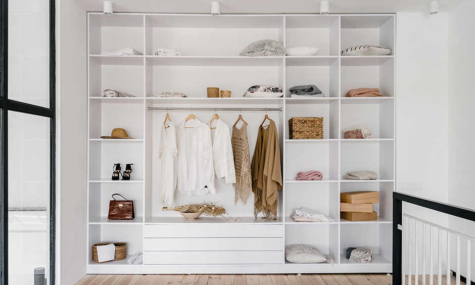 Minimalist women wardrobe designed in white colour with its finely divided storage option looks elegant.
