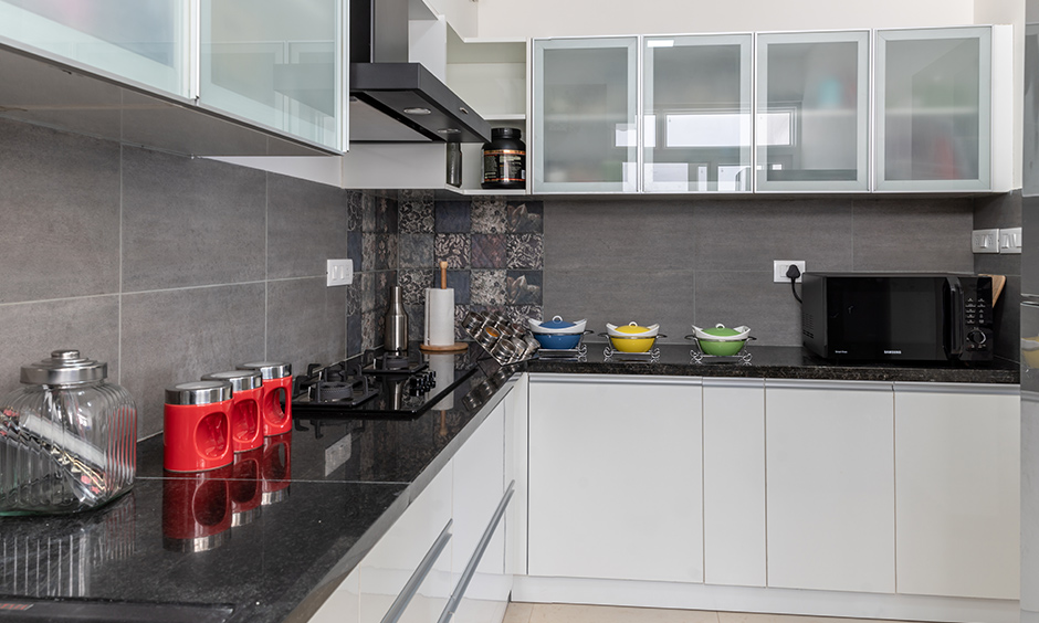 Best interior designers in Kanakapura road Bangalore designed this l-shaped minimalistic kitchen with a white high-gloss laminate.