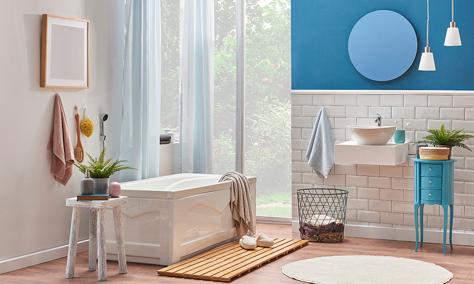 Modern bathroom decor ideas- decorate with blue console stool, drop-downlights, and laundry bin.