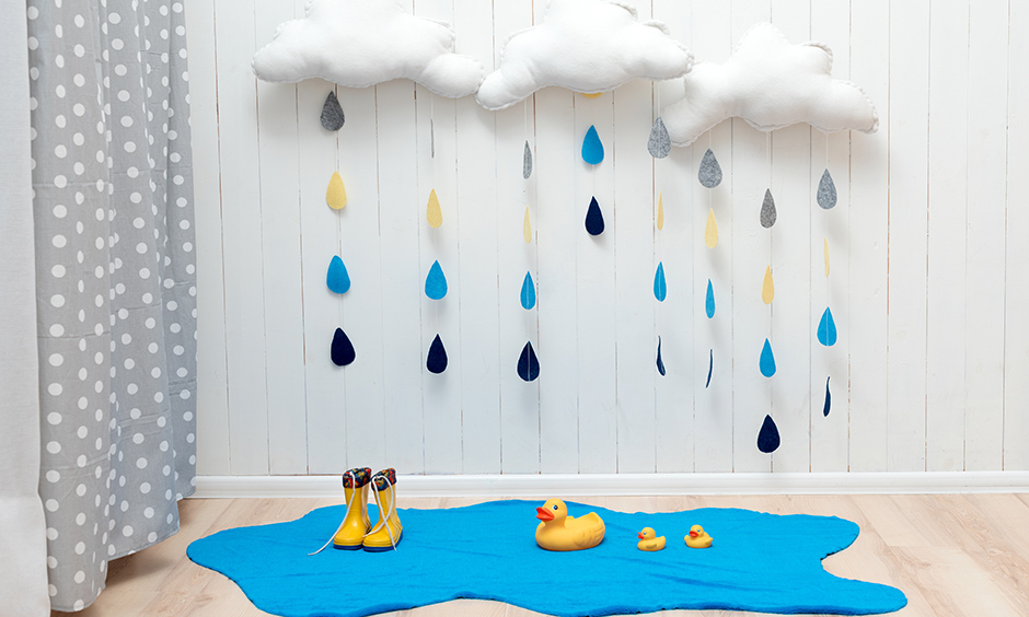 A rainy day DIY paper wall hanging in a kids room using pillow & coloured foam paper.