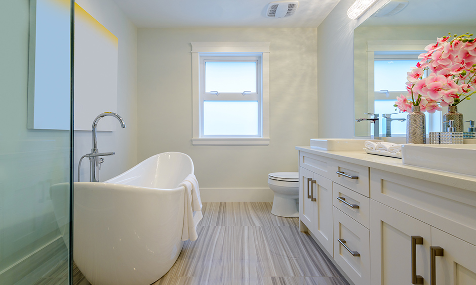 Minimalist bathroom decor designed with pink flowers in a vase placed on the cabinet makes a difference.