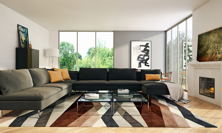 White walled living room with black & dark grey sofa set colour combination & yellow pillows brings in a fun twist.