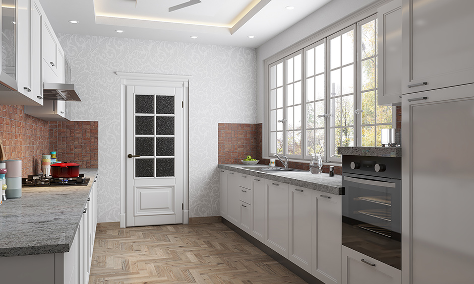 White coloured open cabinets and the countertop attached beside the window made in a very small space of a small parallel kitchen design in india