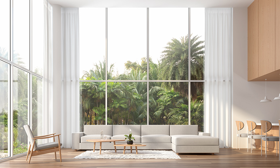 A house lobby design with a grey sofa next to the breakfast bar and huge bay windows for natural light is classy.