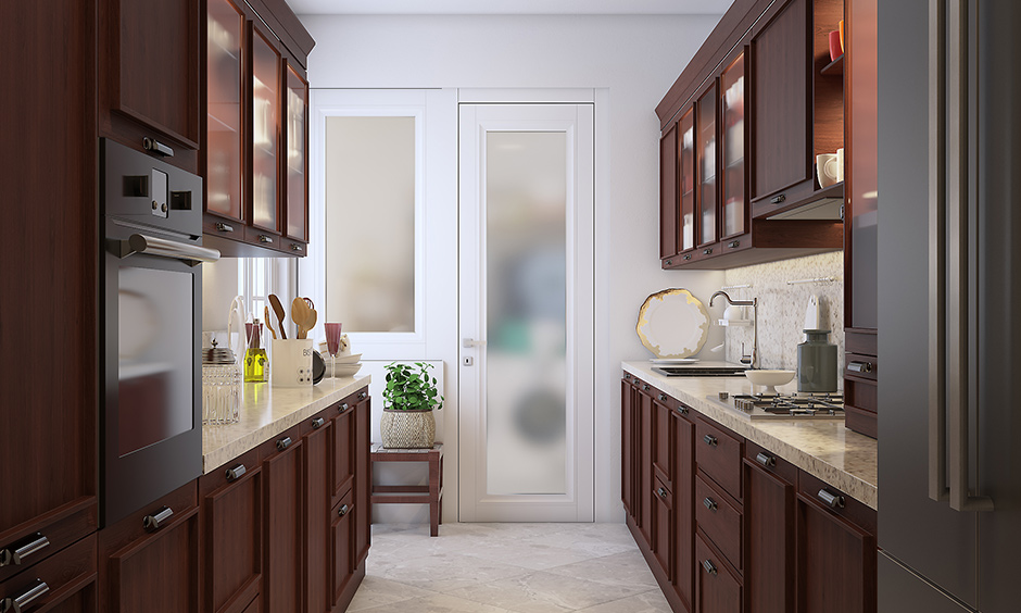 A wooden cherrywood finish modular kitchen with marble countertops and cabinet on each and every side of parallel platform kitchen designs