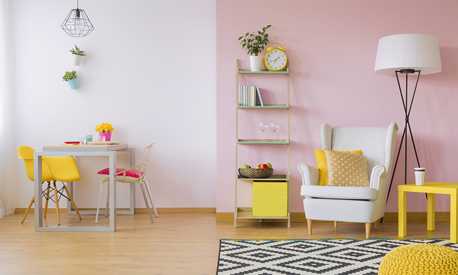 In this room white & pink, dual-wall paint colours segregate living & dining area look bright and cheerful