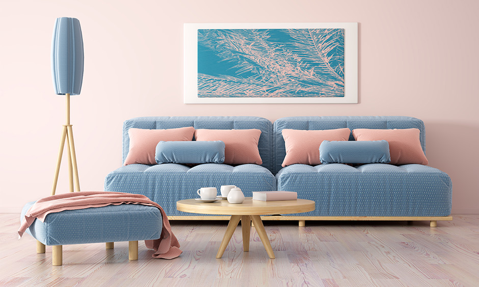 Pastel pink wall paint colour in this room with a blue sofa & pink pillow works fabulously.