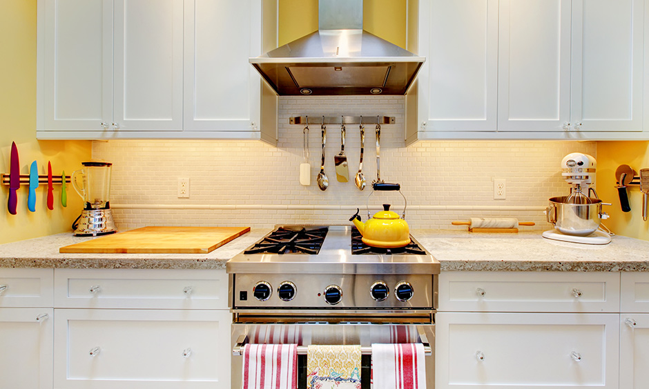 Pastel yellow wall paint colour in the kitchen with all-white cabinetry is bright & stunning.