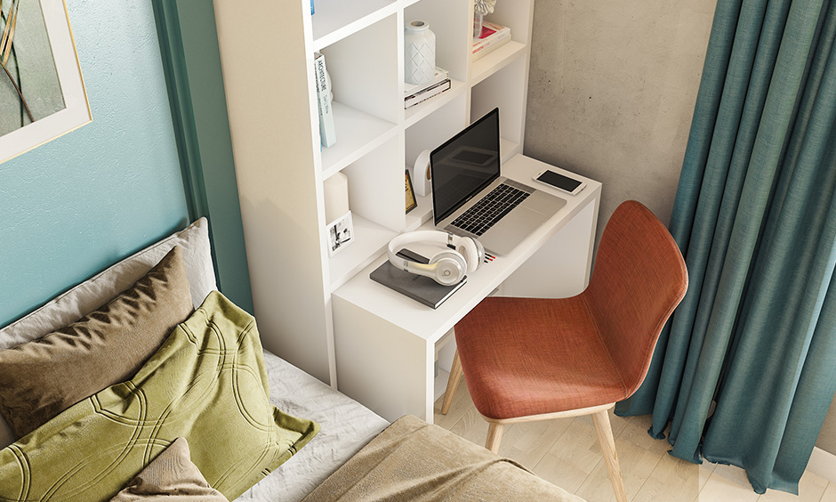 White bookshelf with pull out study unit goes back when not in use is small 1bhk flat interior design.