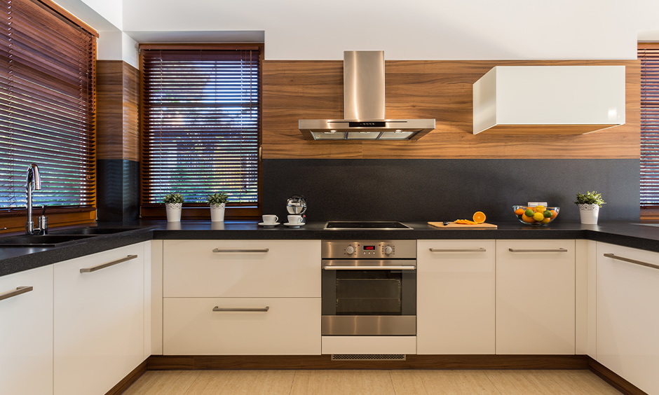 U-shaped modern white kitchen cabinets with black countertops bring a beautiful rustic touch to the area.