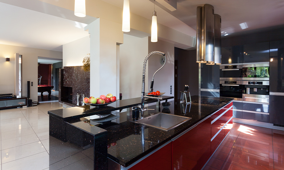 Black marble kitchen countertops with push to open drawers and cabinets in red lamination looks gorgeous.