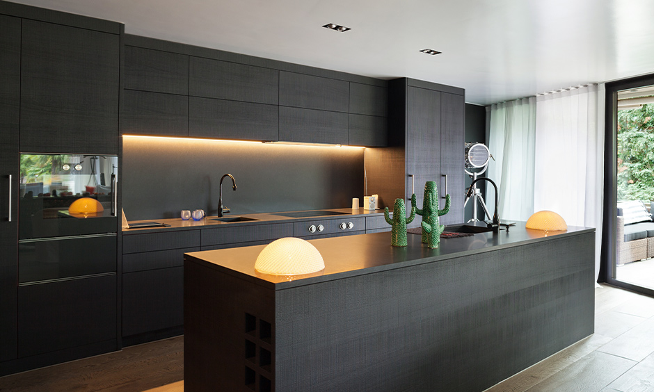 Black granite countertops kitchen in black with LED strip lighting at the backsplash is adorable.