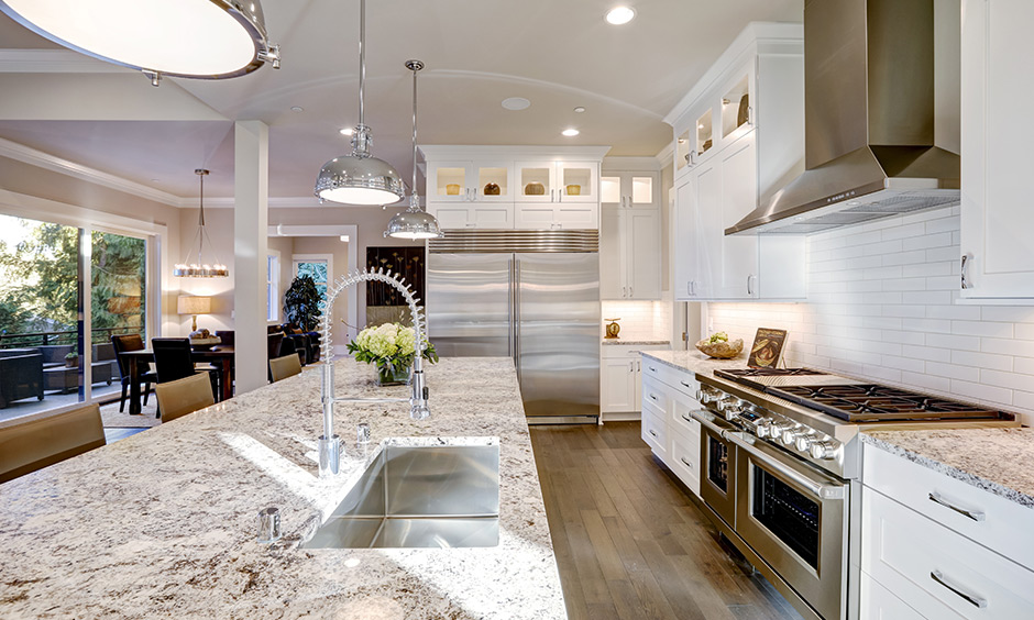 Modern white kitchen with granite countertops and backsplash in a brick pattern look luxurious and elegant.