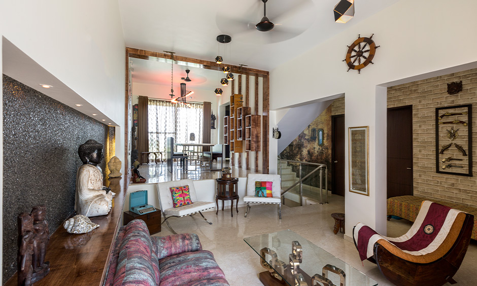 Modern living room designs Indian style with an olden day chair, coffee table, artefacts and a rustic touch.